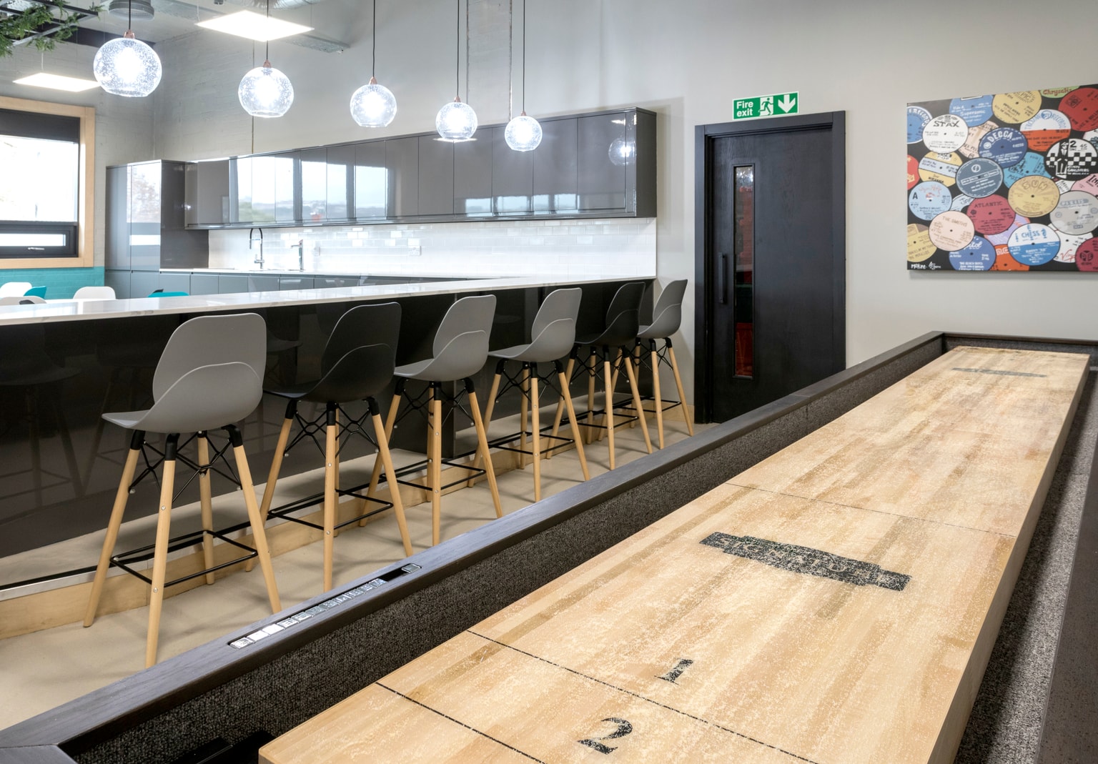 Image of kitchen area with a shuffleboard table in forefront of the image