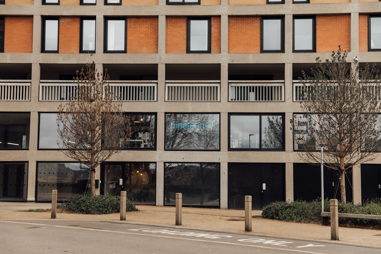 Image of nineteen47 Office building from the outside showing park hill flats and a neon blue nineteen47 logo