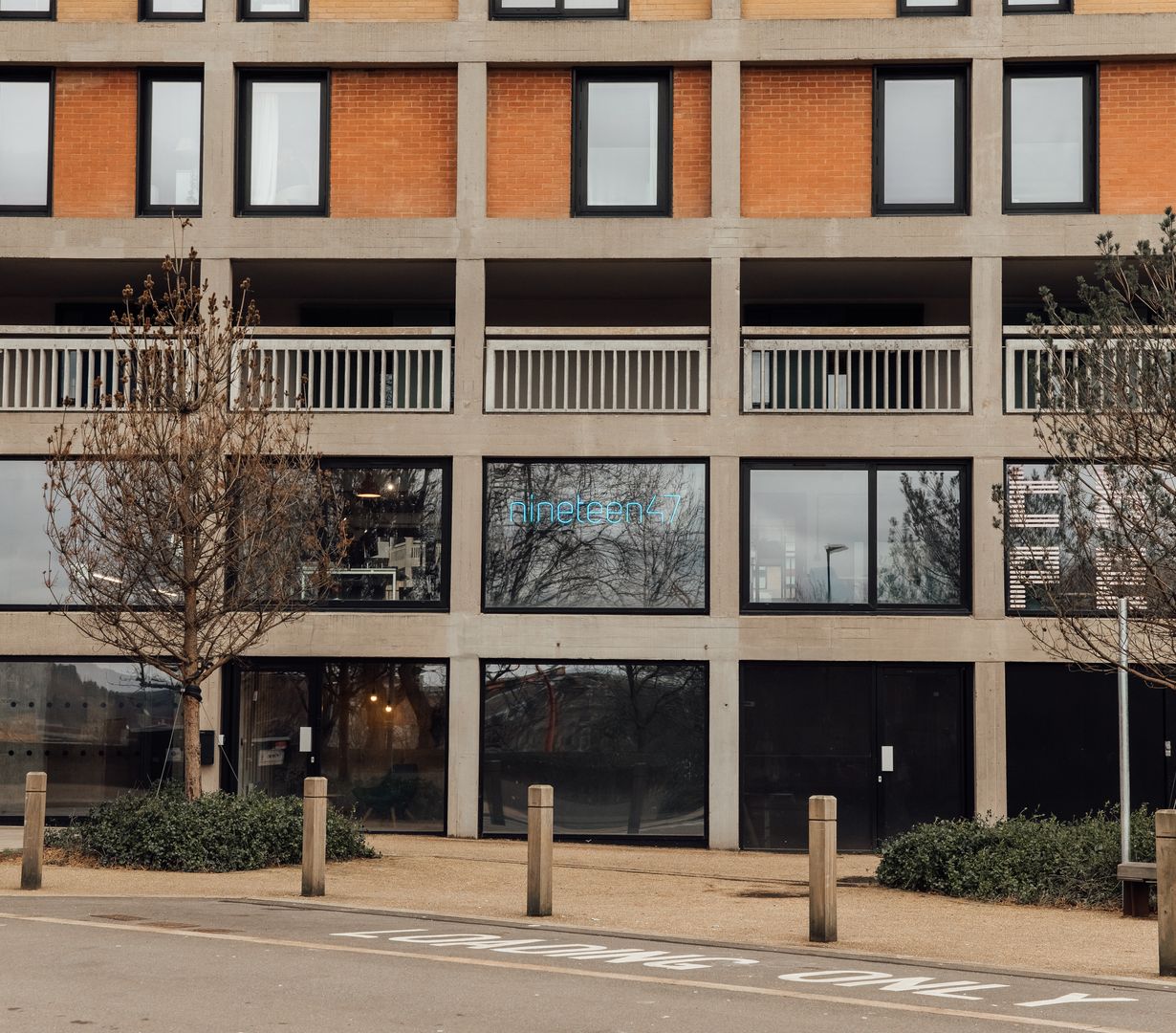 Image of nineteen47 Office building from the outside showing park hill flats and a neon blue nineteen47 logo