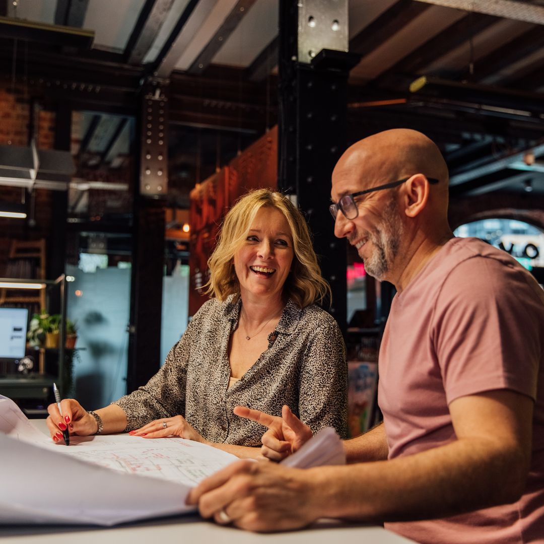 Image of colleagues discussing work over a computer